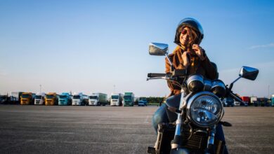 Mulher de moto prendendo capacete