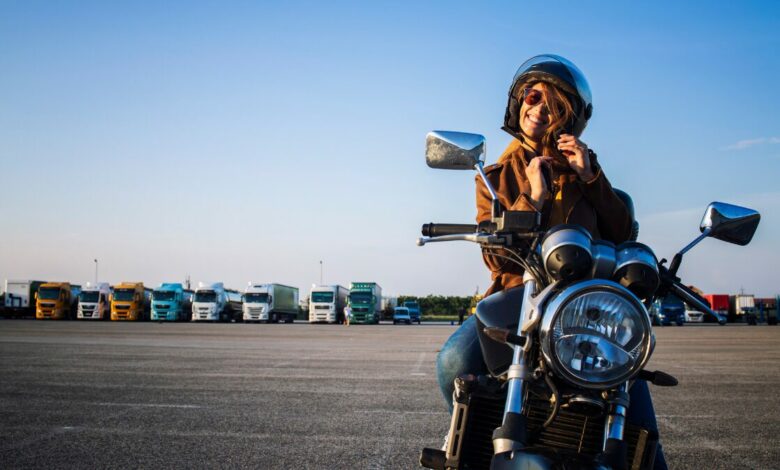 Mulher de moto prendendo capacete